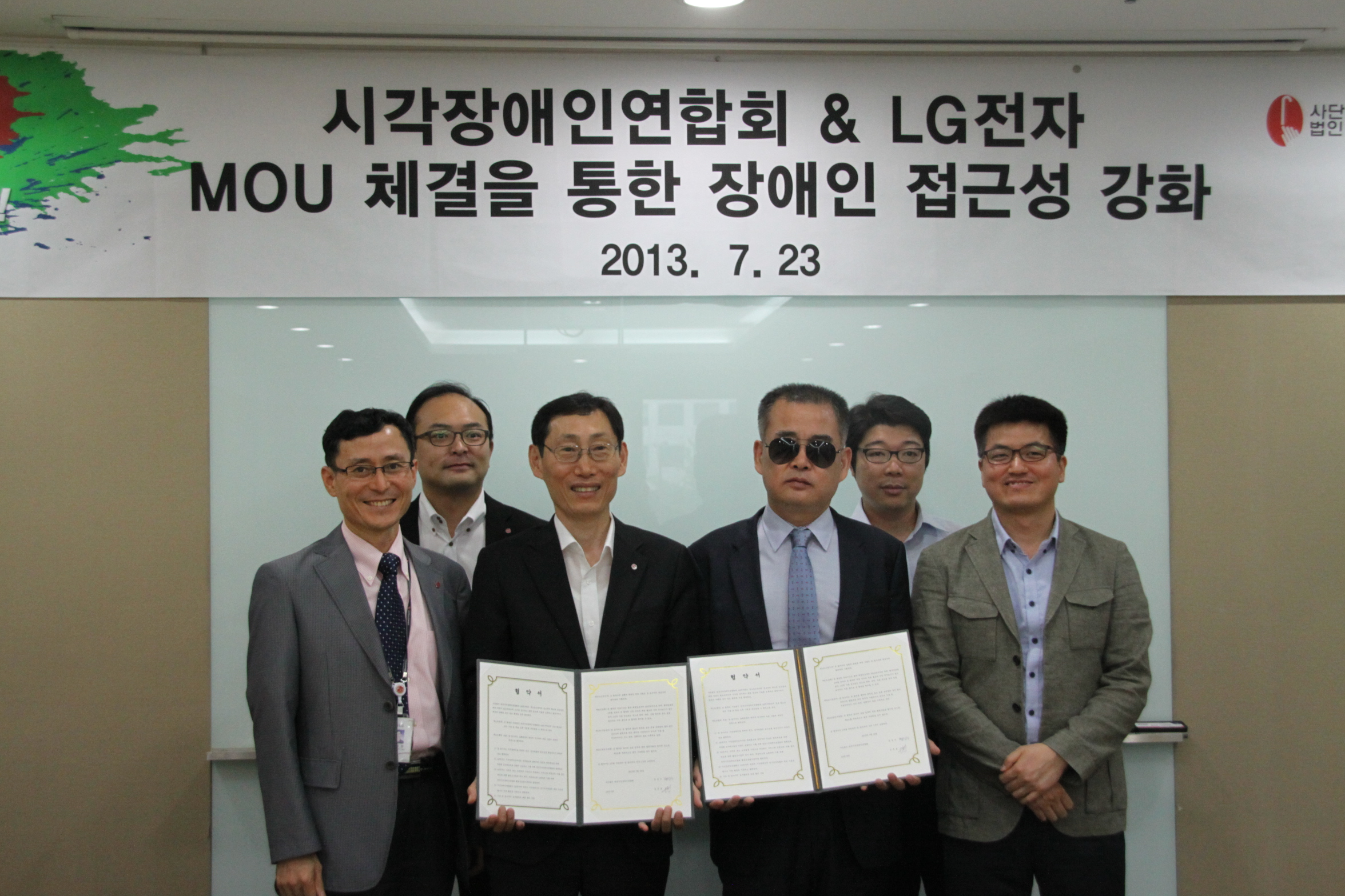 한국시각장애인연합회, LG전자 관계자들이 업무협약서를 들고 있는 모습