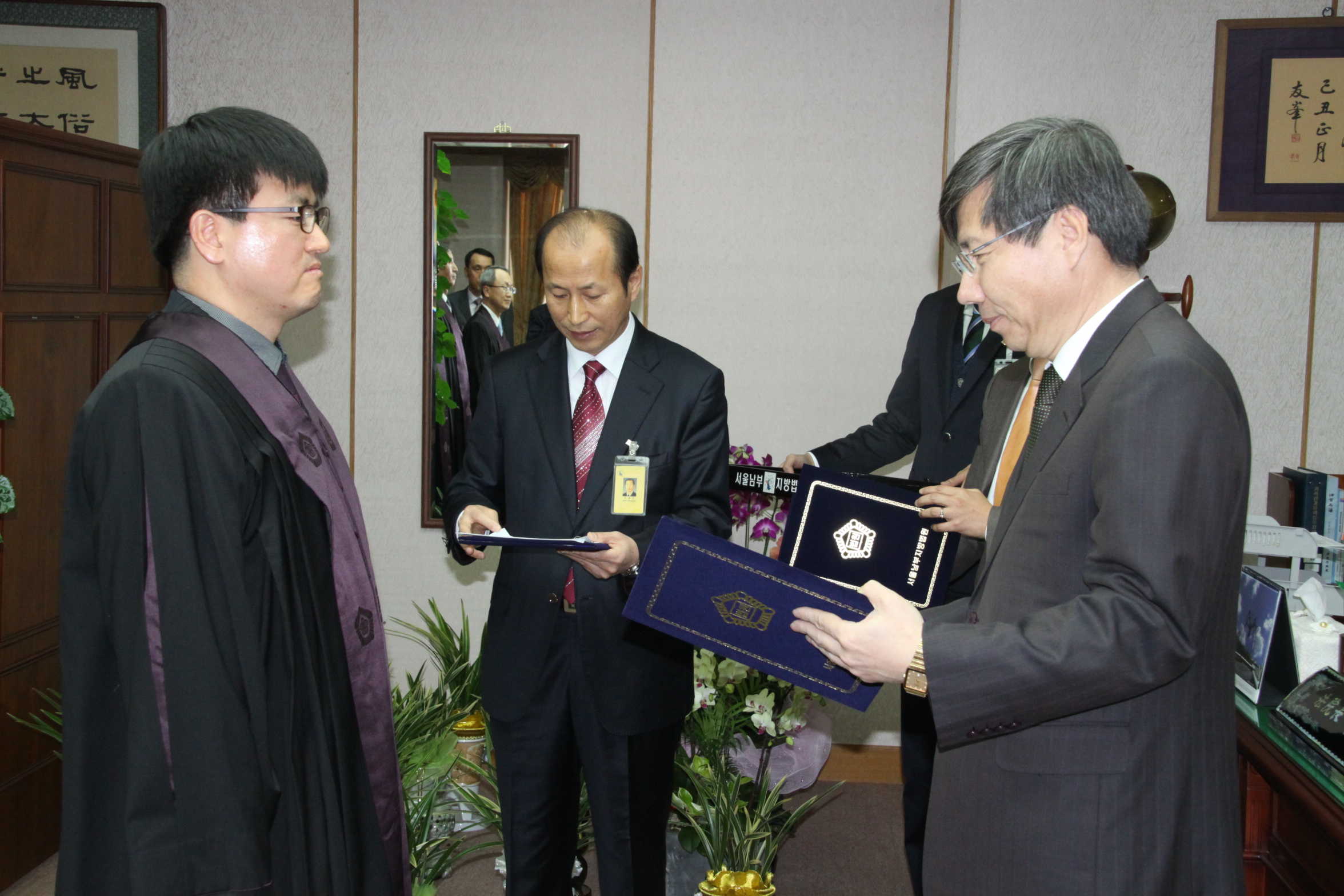 서울남부지방법원 김문석 법원장에게 명예법관 위촉을 받는 김두현 관장